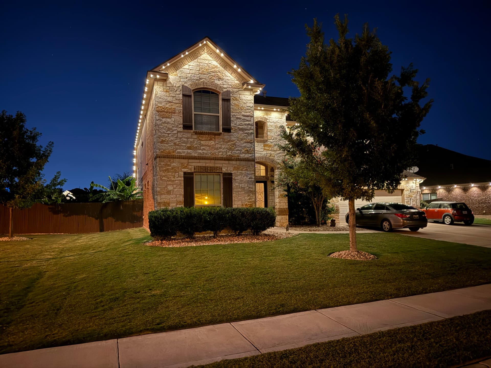 Permanent warm white RGBW lighting on an Austin home at dusk
