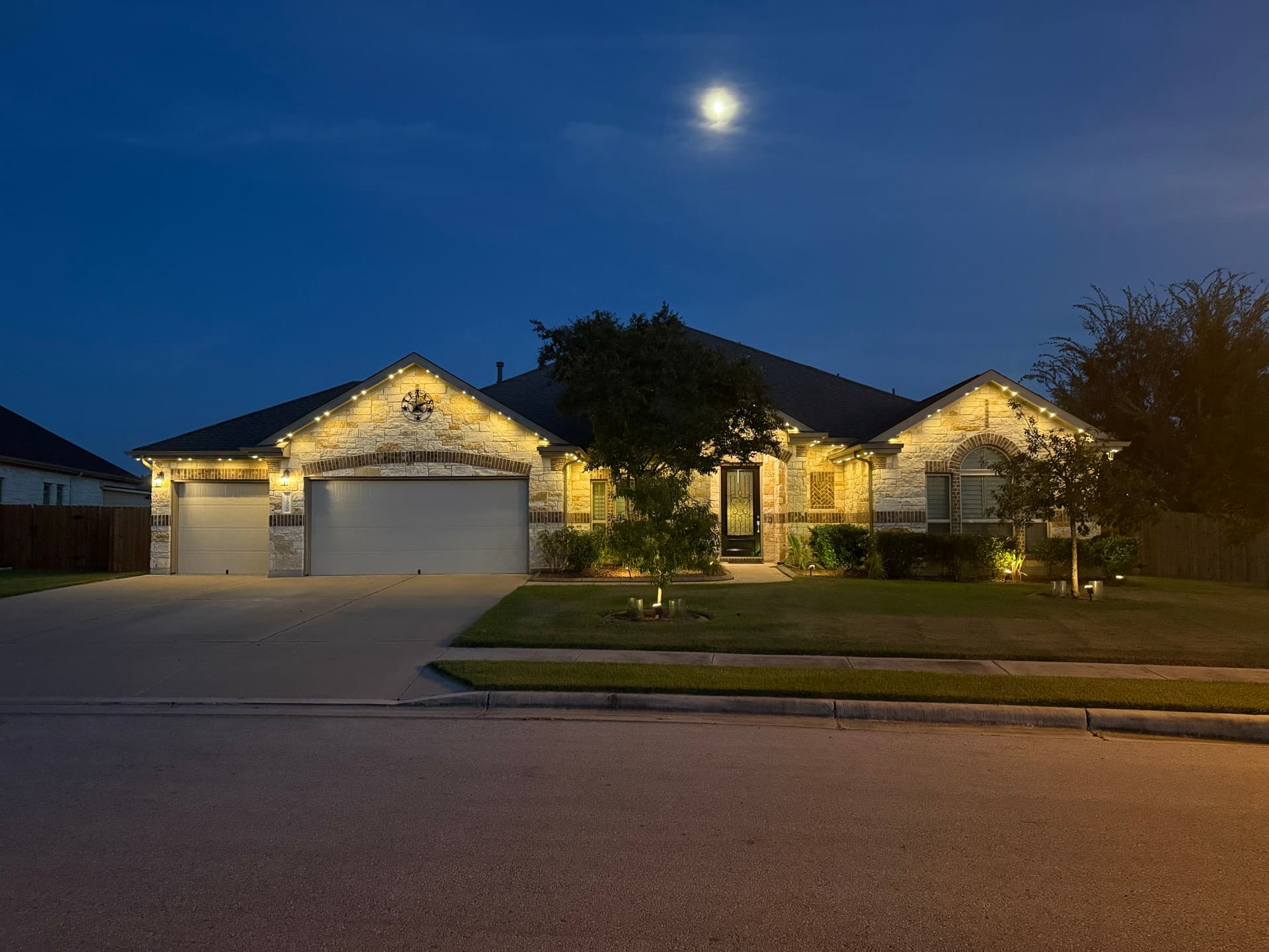 Permanent warm white RGBW LED roofline lighting on an Austin Hill Country home at night