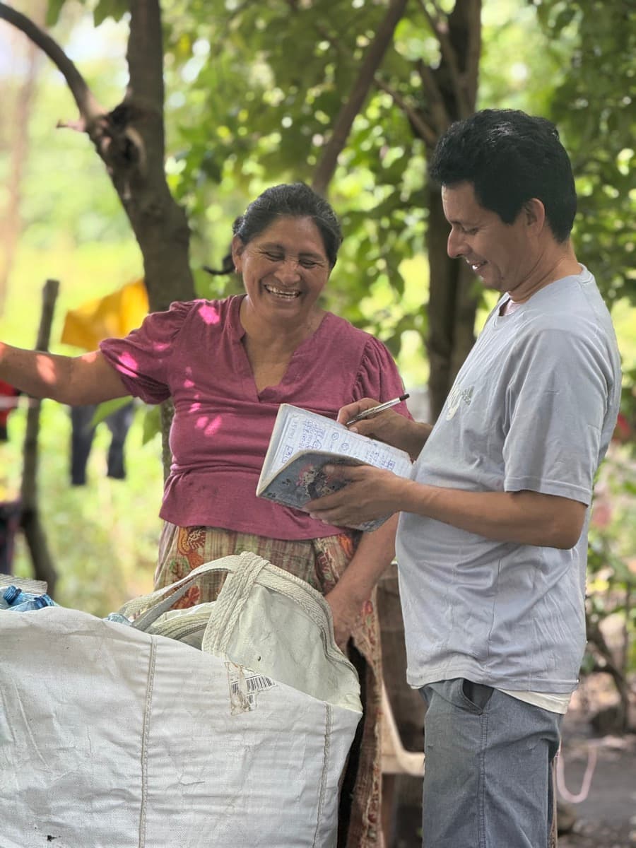 Tidey Ocean worker at plastic collection hub with large bags of recovered bottles