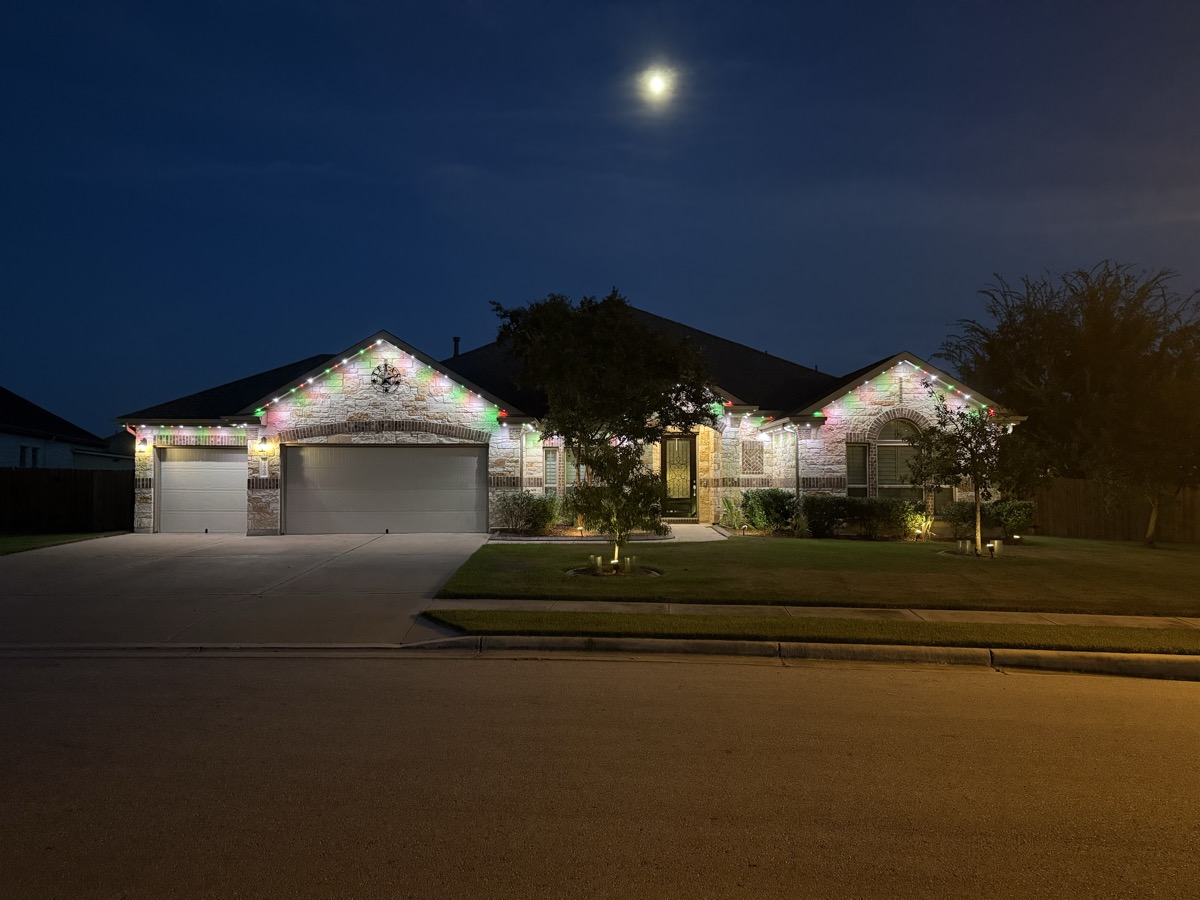 Professional permanent lighting installation on an Austin limestone ranch home
