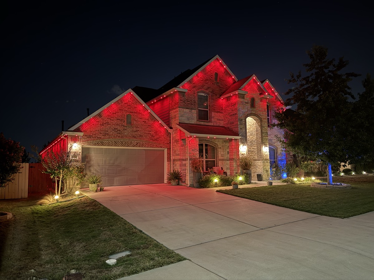 Completed permanent LED lighting installation on a large Austin home at night